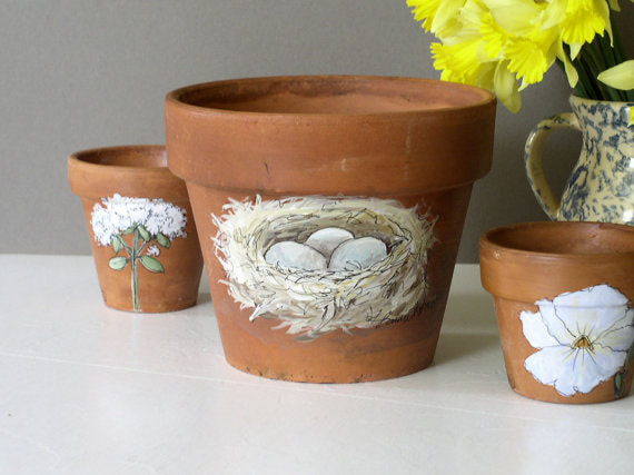 painted clay pots with birds nests flowers herbs